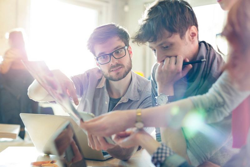 Creative business people reviewing proofs in sunny office